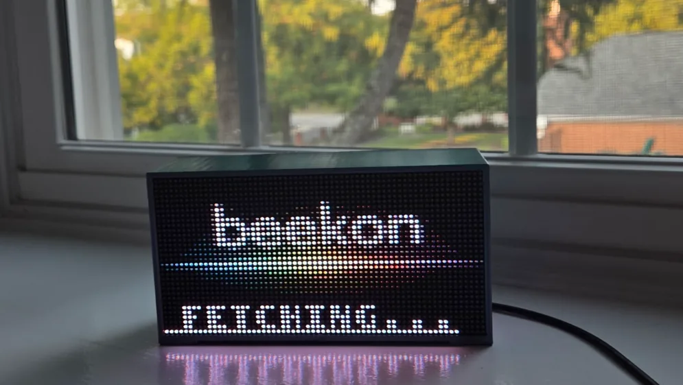 Close-up of Beekon Light glowing with the word beekon above a rainbow of pixels