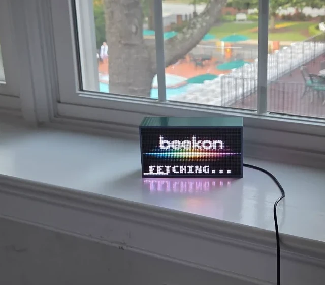 Beekon Light on a white windowsill, plugged into the wall outlet below